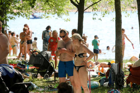 MINSK, BELARUS - 22 July, 2022: people sunbathing on the beach by the lake in the cityの写真素材