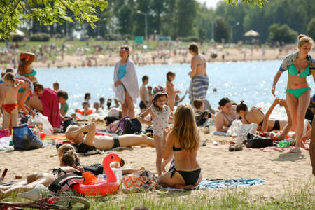 MINSK, BELARUS - 22 July, 2022: people sunbathing on the beach by the lake in the cityの写真素材