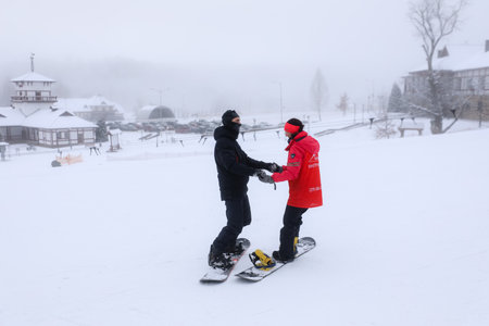 MINSK, BELARUS - 9 SEPTEMBER, 2022: trainer teaching snowboardingの写真素材