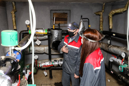 MINSK, BELARUS - 9 SEPTEMBER, 2022: girl plumber repairs pipesの写真素材