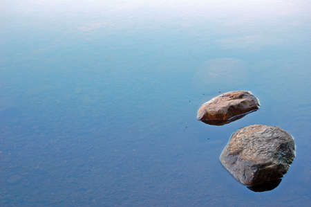 Two loneless stones in lake waterの写真素材