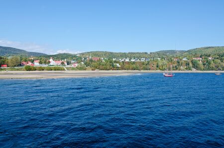 Sunbeam on dark sky above the sail boat on St. Lawrence riverの写真素材