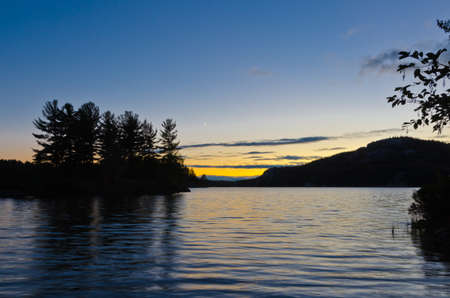 Sunset above forest lake in Killarney park, Canadaの写真素材