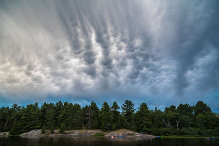 Clouds above forest lake in Grundy Lake park, Canada