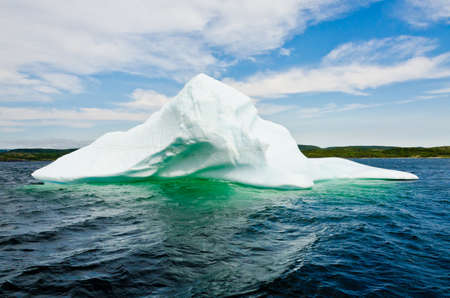 Bright white iceberg on dark water and rock backgroundの写真素材
