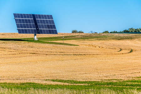 Lone solar panel in Yellow farm field at fall under blue sky in Ontario, Canadaの写真素材