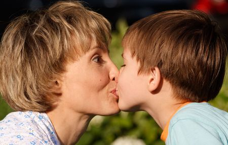 Woman kissing her son, close-up face to face