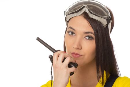 serious female construction worker talking with a walkie talkieの写真素材
