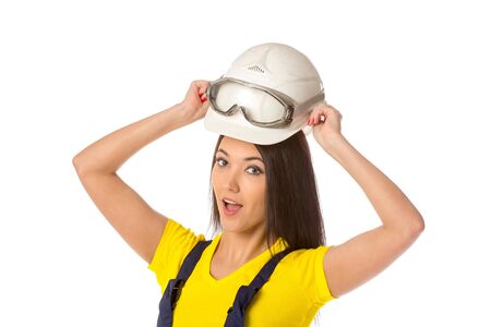 Serious female construction worker in helmet with gogglesの写真素材