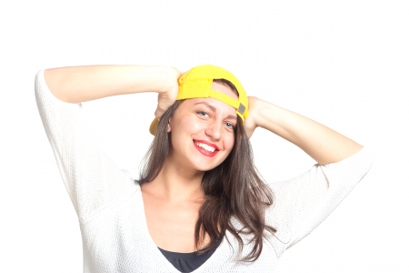 Attractive young woman wearing a yellow baseball cap, isolatedの写真素材