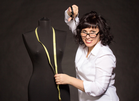 Adult tailor with mannequin on blackの写真素材