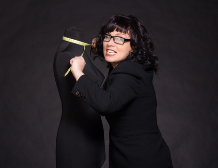 Adult tailor with mannequin on blackの写真素材