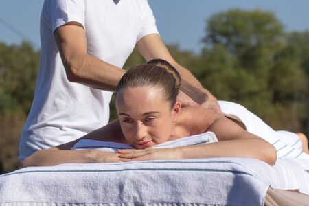 Caucasian woman lying on a massage table outdoorspの写真素材