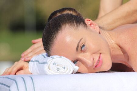 Caucasian woman lying on a massage table outdoorsの写真素材