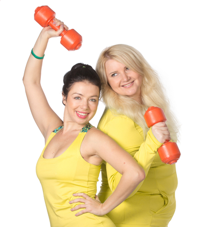 Woman team pumping up muscules with dumbbellsの写真素材