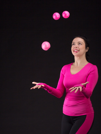 Brutal athletic woman plays ball on black backgroundの写真素材