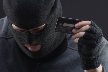 Hacker hold stolen credit card in handの写真素材