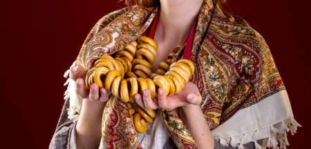 Russian barankas in woman hands wth national scarf on red backgroundの写真素材