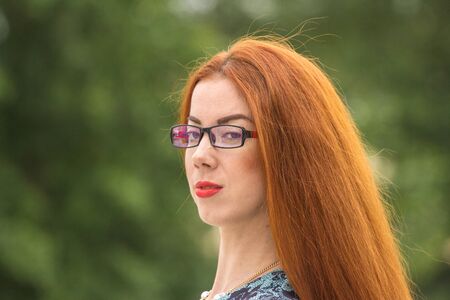 Ginger woman close up portrait on green background