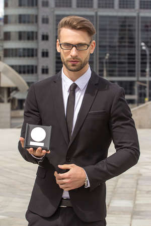 Happy Businessman with award on urban backgroundの写真素材