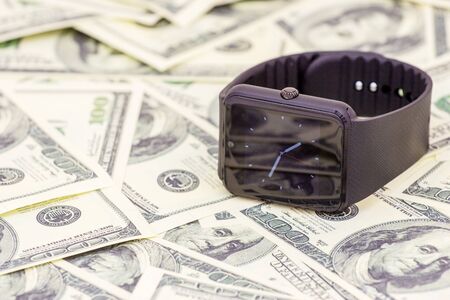 Black Smart watch on dollar banknotes