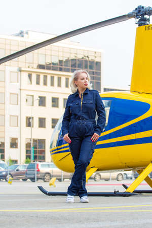 Pretty pilot woman on helicopter backgroundの写真素材