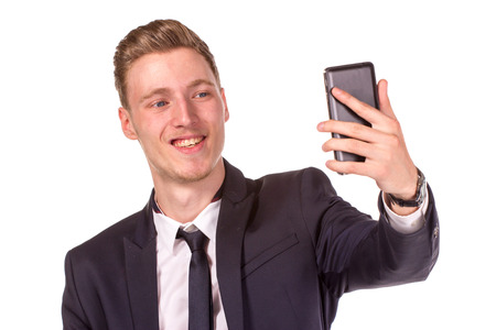 Serious business man using mobile phone. Close up portrait, isolated on white backgroundの写真素材