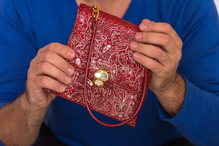 Small female handbag in strong male hands