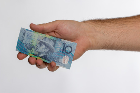 Man hold 10 Australian dollar Banknote. Isolated on white.の写真素材