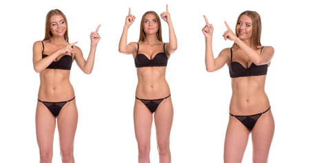 Cute Sensual Sexy Attractive Young Nordic Pin Up Model Wearing Black Lingerie Against A White Background. Woman showing up direction by fingersの写真素材