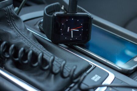 Modern car interior with smart watch and smart phone on gear stick.の写真素材