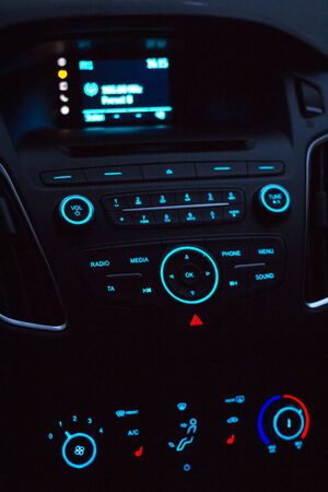 Dashboard with audio equipment and heater control in cabin of the modern new car at nightの写真素材