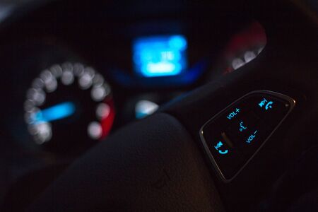 Steering wheel on modern car dashboard background at night. Selective focus.の写真素材