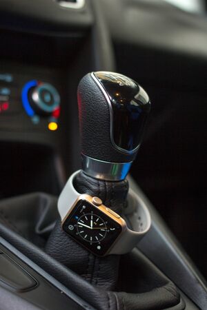 Modern car interior with smart watch on gear stick.