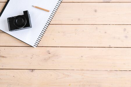 Hobby concept. Top view of photo camera lying on the table near notebookの写真素材