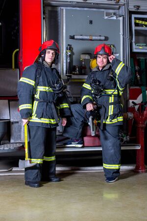 Portrait of a fireman with car on background