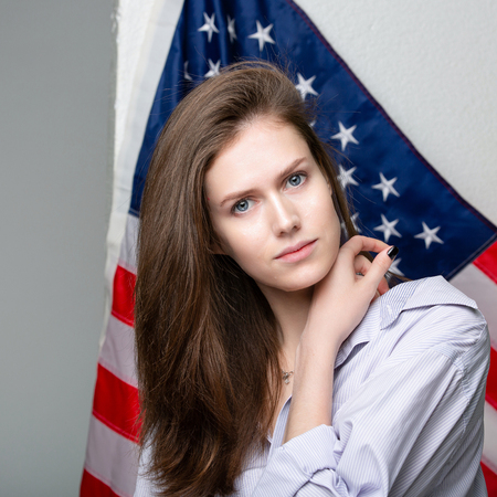 Beautiful caucasian woman with Flag of United States of America on background.の写真素材