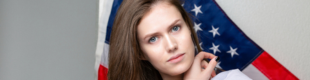 Beautiful caucasian woman with Flag of United States of America on background.の写真素材
