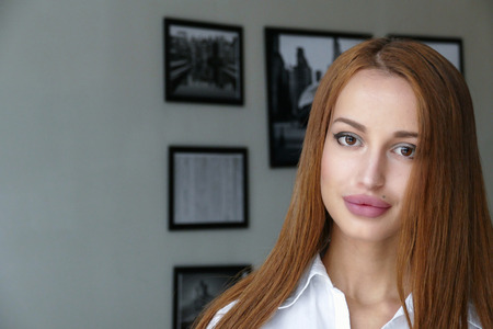 Beautiful girl in white shirt, indoors portraitの写真素材