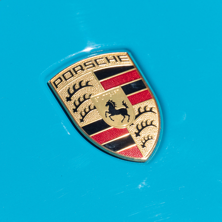 Porsche logo on blue cars hood. Close up view. SEP 26, 2018 MOSCOW, RUSSIA
