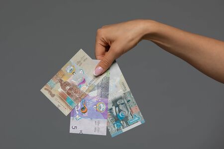 Kuwaiti dinar banknote in hand of young woman. Kuwaiti dinar is the national currency of Kuwaitの写真素材