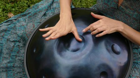 Beautiful female hands on a perfect musical percussion instrument. Sound Meditationの写真素材