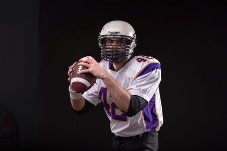 Close up portrait of American Football Player posing in studio wearing violett uniform