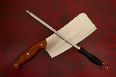 Knife and Sharpener On A Cutting red wood Board