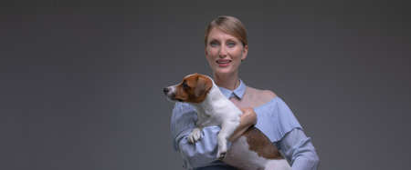 Blond woman in vintage dress hold jack russell puppy