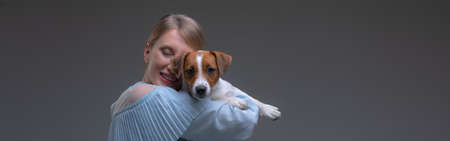Blond woman in vintage dress hold jack russell puppyの写真素材