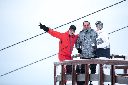 3 Skiers posing against the background of the ski liftの写真素材