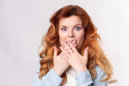Shocked red-hair Model posing in studioの写真素材