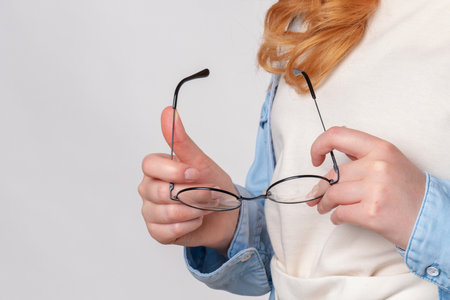 Ginger woman Holds glasses in hands