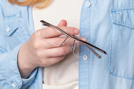 Ginger woman Holds glasses in handsの写真素材